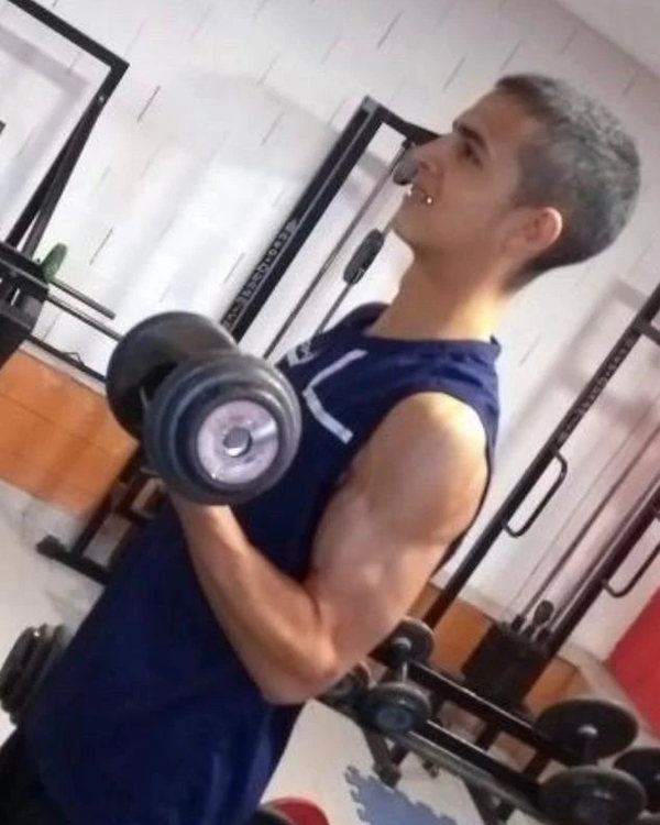 Benja en una foto de antes, entrenando bíceps con una mancuerna